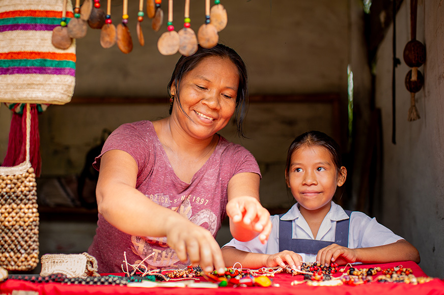 A mother and her daughter sell jewellery from a little stall in their local village.