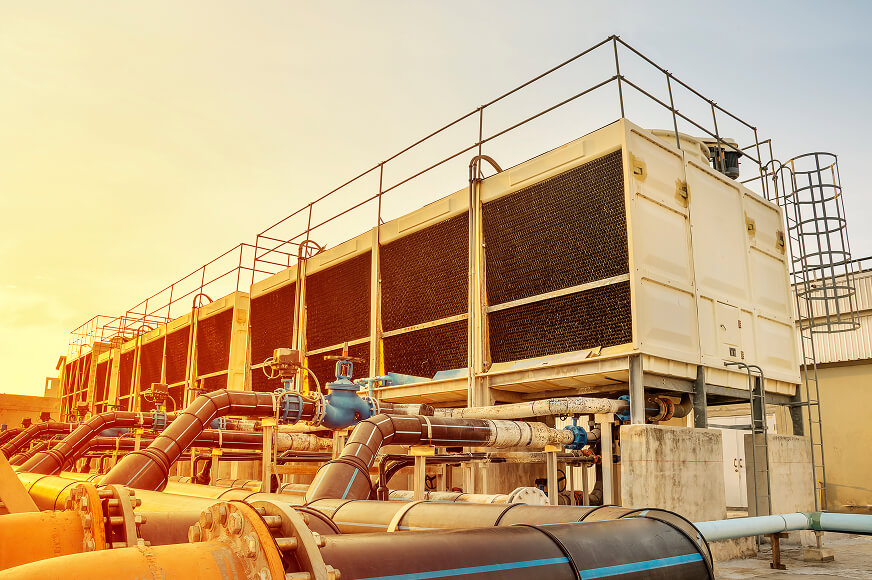 Industrial cooling towers and large water pipes used for temperature regulation at a data centre facility.