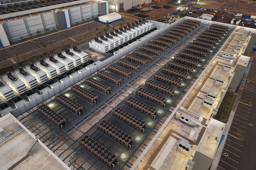 Large-scale industrial data centre facility featuring extensive rooftop cooling and ventilation systems.