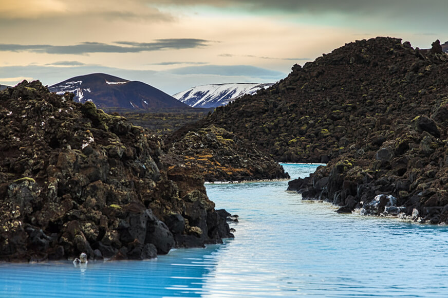 Clean water in Iceland with a mountain in the background.