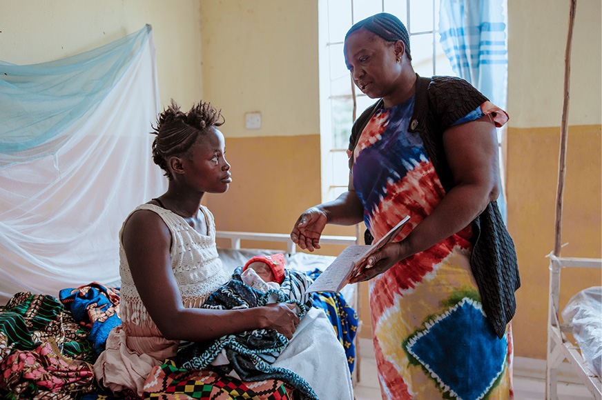 A mother and baby are seen by a healthcare staff in a local clinic.