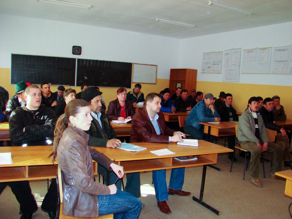 A group of Romanian farmers are learning in a classroom through the Economic Development Project