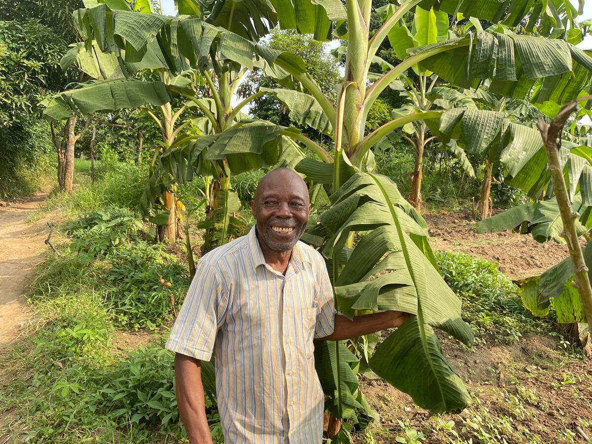 Man-standing-by-banana-plant-WVC-farming-into-education