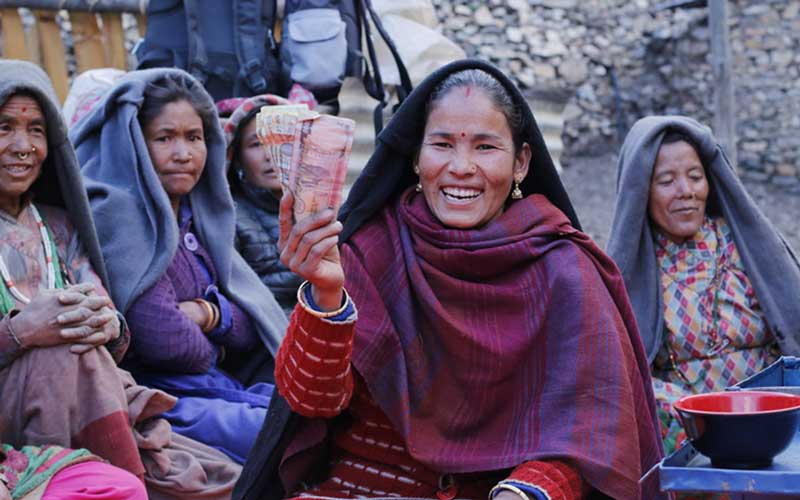 Poverty Reduction - woman smiles while holding money