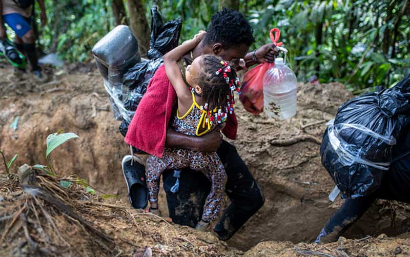 darien-gap-migrant-route-man-carrying-child