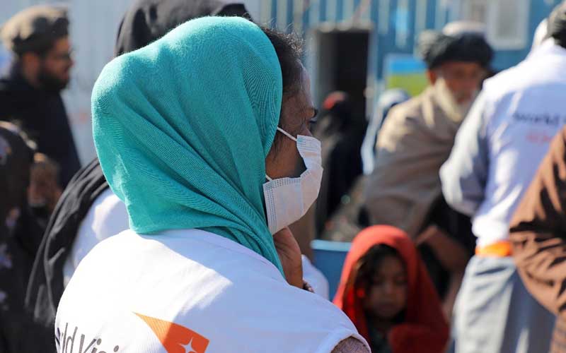 The back of a World Vision Vision staff wearing a mask.