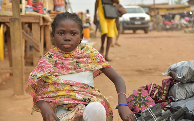 Sourcevie from Congo sells coals in a market in Congo to pay for her schooling.