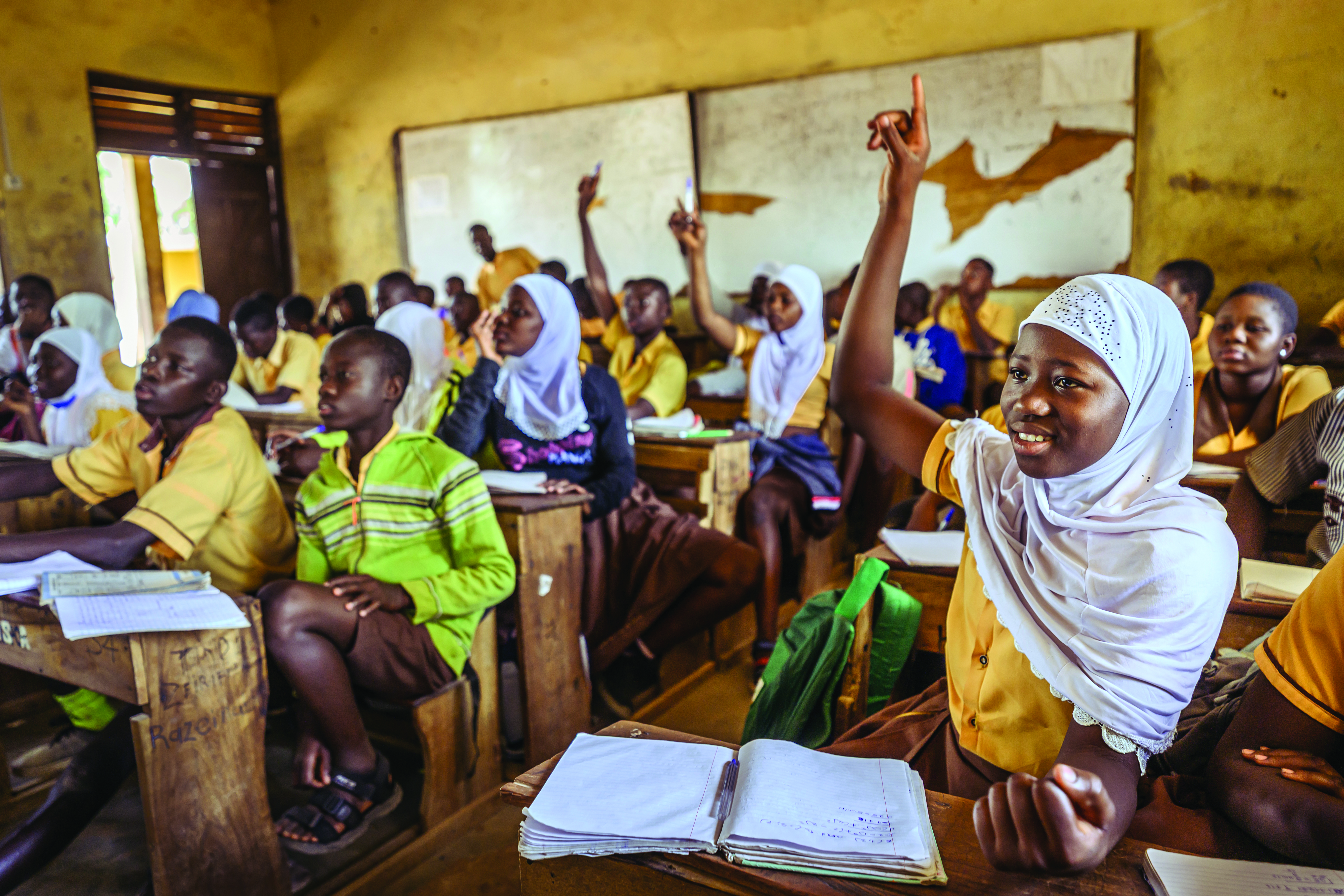 Une jeune fille de 14 ans lève la main dans une salle de classe au Ghana