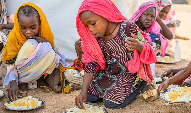 world-vision-canada-sudan-crisis-children-eating-on-the-ground.webp