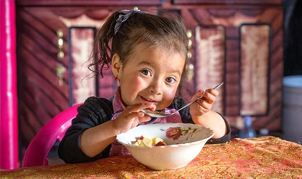 world-vision-canada-young-girl-child-enjoying-her-food.webp