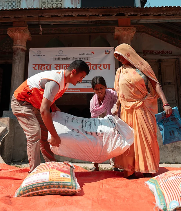 about-us-world-vision-staff-giving-relief-kit-to-woman-and-child-6.webp