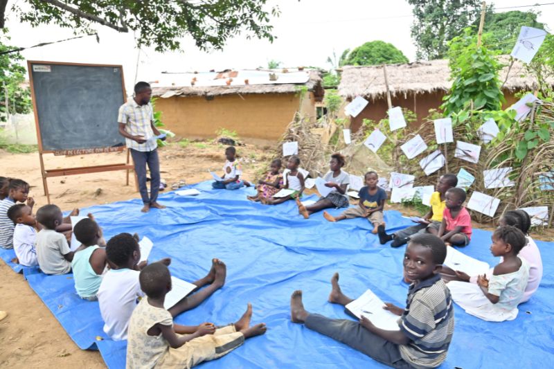 Junior listens to the reading club lesson with his classmates.