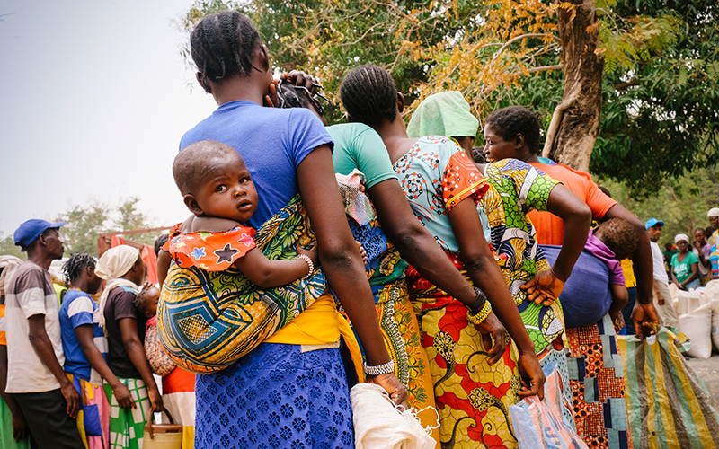 Des mères de la République centrafricaine font la file pour recevoir des articles de secours; certaines portent leurs bébés attachés dans le dos à l’aide d’une écharpe.