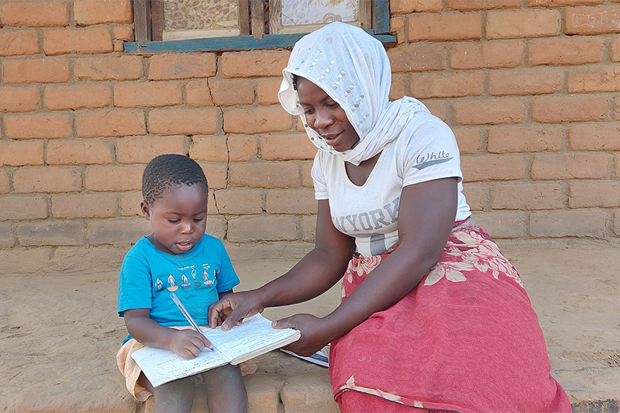 Sellina et son fils en train d'écrire à la maison