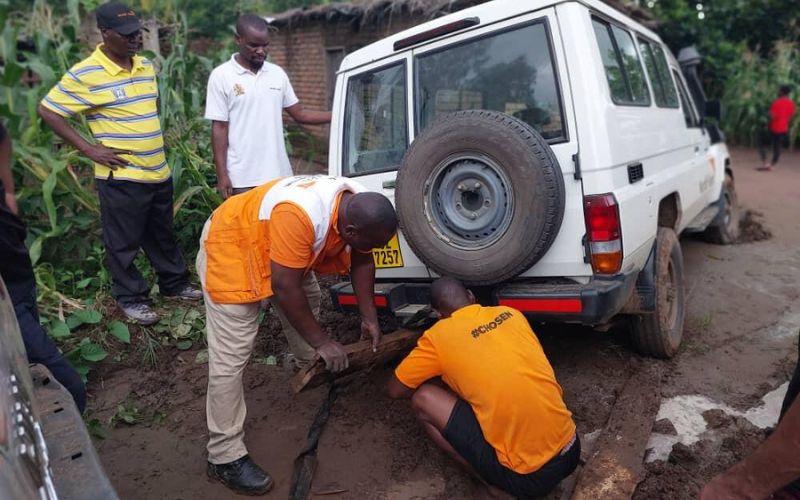Les employés de World Vision calent un camion enlisé dans la boue sur un versant afin de le remonter.