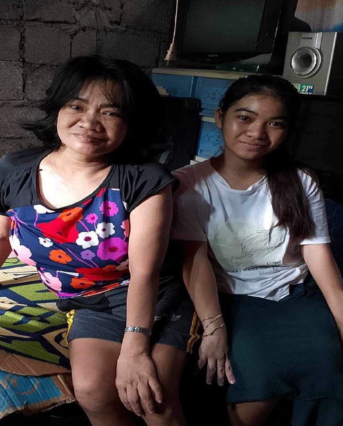 Une adolescente et sa mère posent pour une photo aux Philippines.