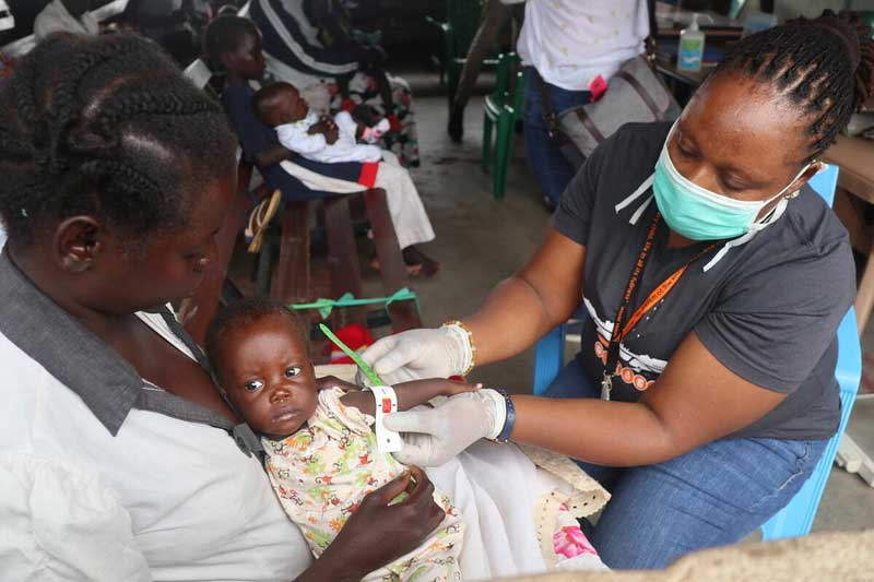 Un employé de World Vision au Soudan du Sud mesure la largeur du bras d’un bébé.