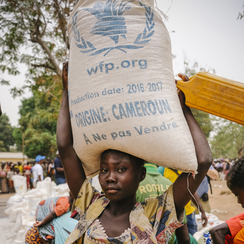 En République centrafricaine, une femme porte un sac de provisions d'urgence sur la tête.