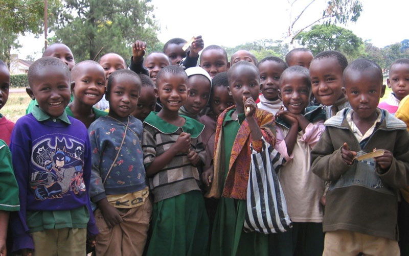 Un groupe d'enfants en Tanzanie sourit à la caméra.