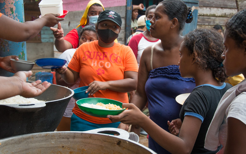 Des femmes et des filles du Nicaragua font la file devant une cuisine communautaire pour recevoir de la nourriture.