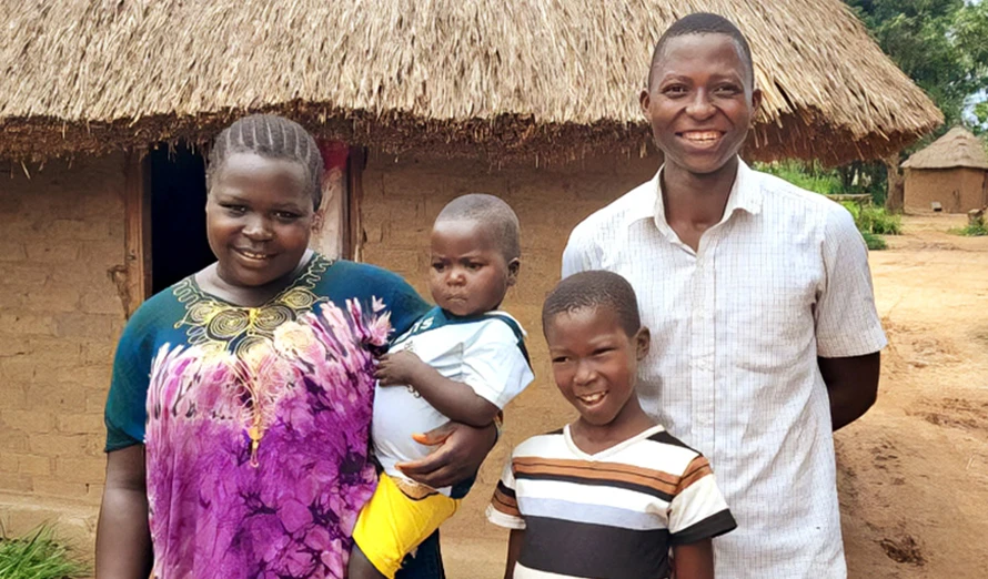 Paul, a farmer in South Sudan, is posing for a picture with his family.