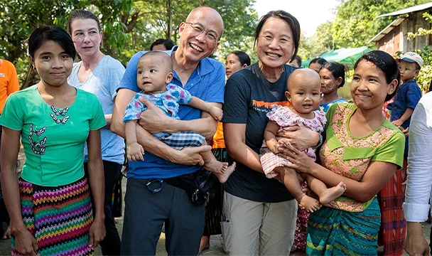 World Vision partners holding a child alongside their mothers.