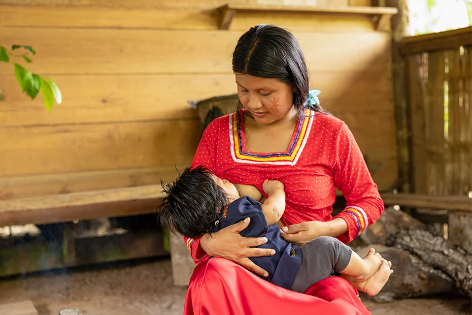 A young mother cuddles her baby as she breastfeeds.