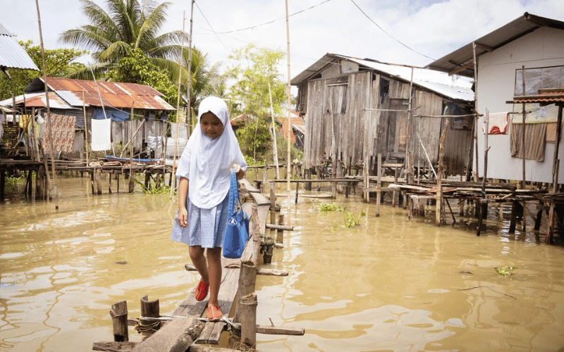 Young girl crosses floodwaters in the Philippines.