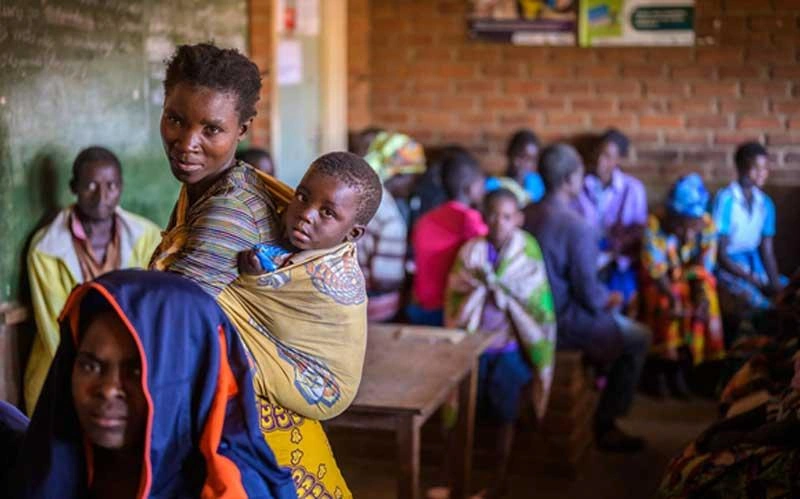 Poverty Reduction - woman carries child in a sling