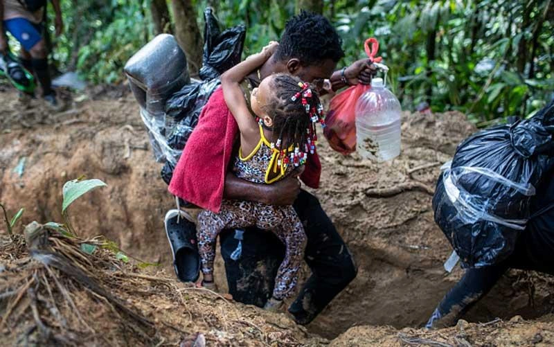 darien-gap-migrant-route-man-carrying-child