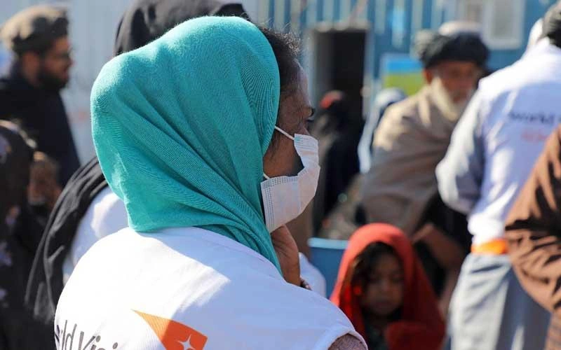The back of a World Vision Vision staff wearing a mask.