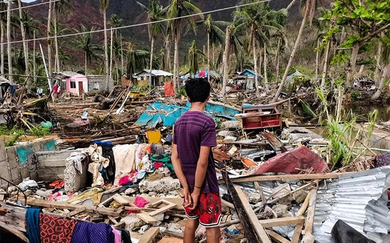 Boy looks at typhoon debris.