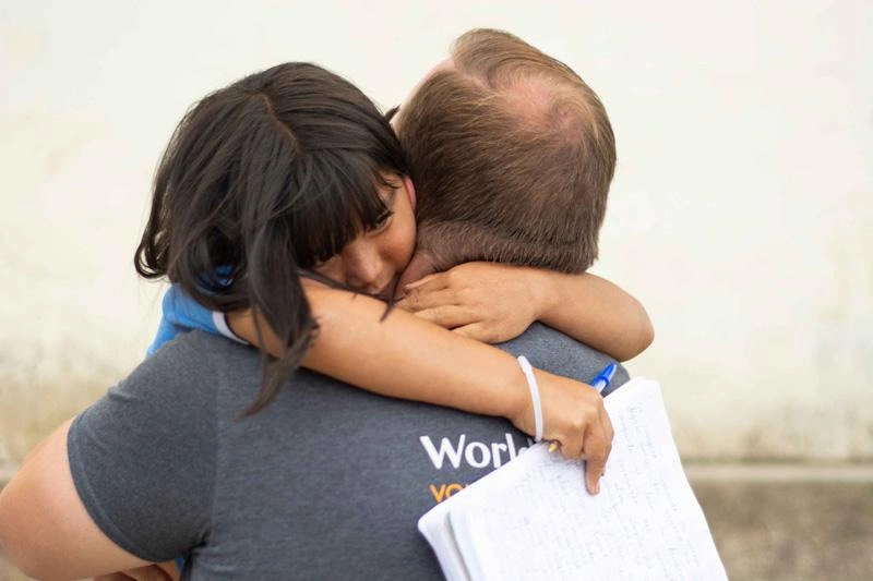 A sponsored child embraces her sponsor.