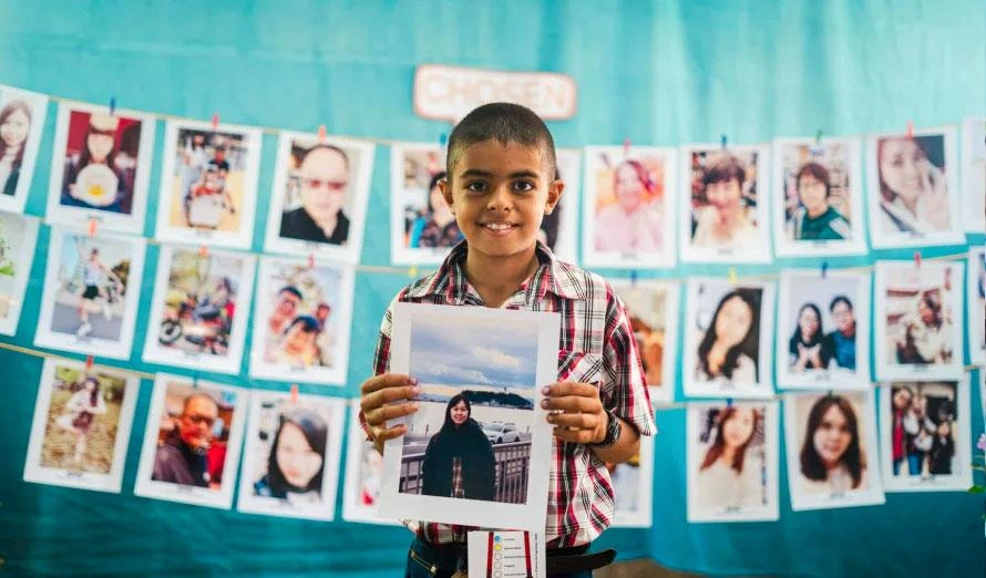 Chosen child holds the picture of the sponsors he chose.