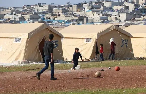 Two boys play soccer in a camp following the earthquake in 2023. (Syria, 2023)
