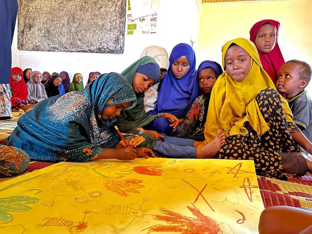 Sucdi sits with her class in Somalia.