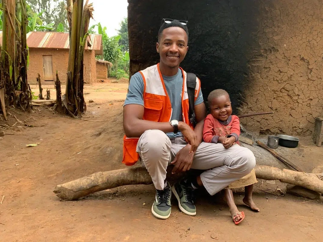 Healthy Hortense sits and smiles with World Vision staff.