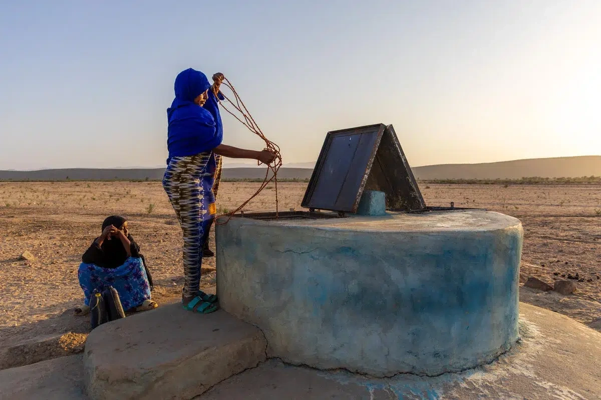 Woman draws water from a well.