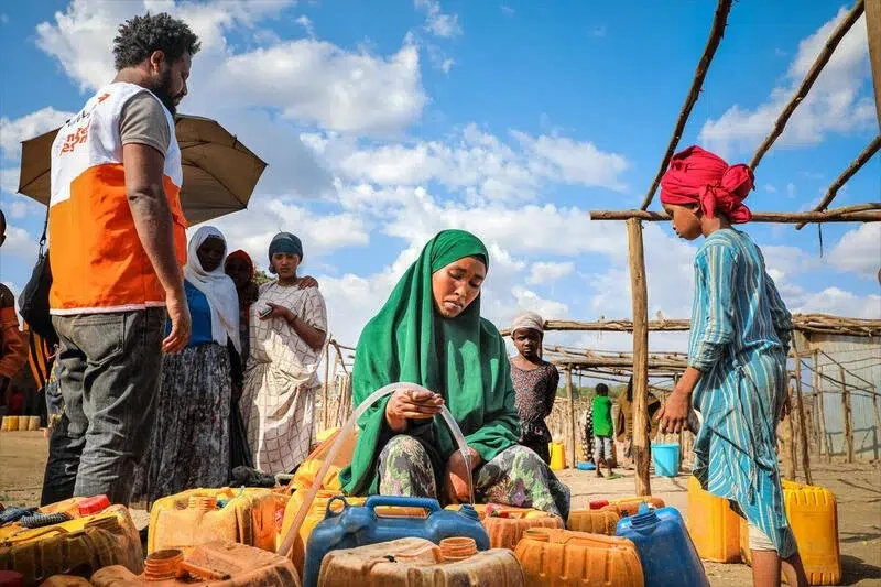 Woman uses emergency clean water brought in for use.