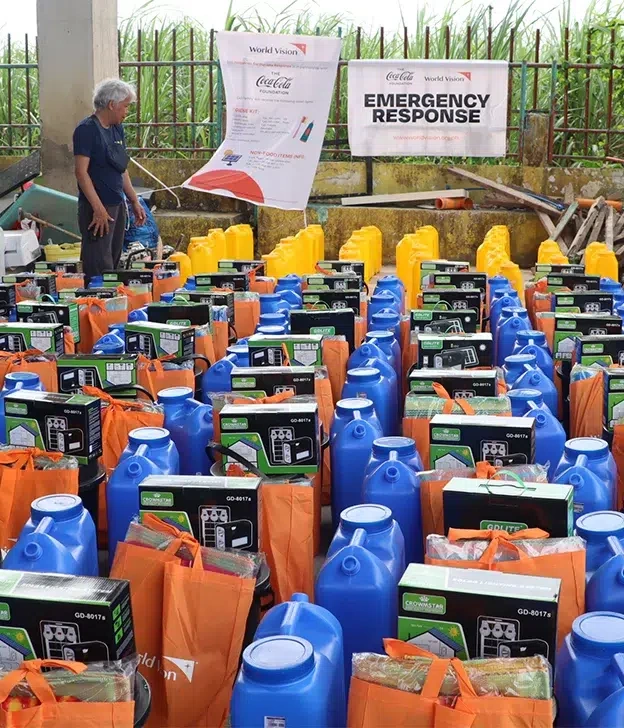 Emergency response supplies, including water containers and aid kits, are organized for distribution during a World Vision relief operation.