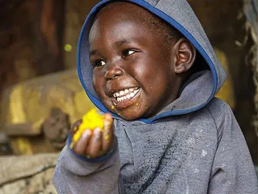 Child being fed an emergency food package.