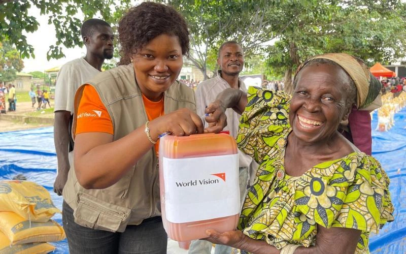 À Kimbanseke, en République démocratique du Congo, deux femmes tiennent un contenant d’huile de cuisson fourni dans le cadre de distributions alimentaires.