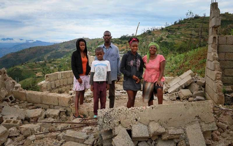 Darien Gap – Route des migrants – Une famille haïtienne debout au milieu des décombres d’un bâtiment