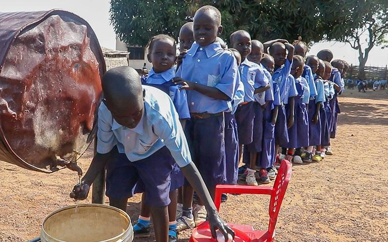 Des écoliers du Soudan du Sud font la file pour se laver les mains.