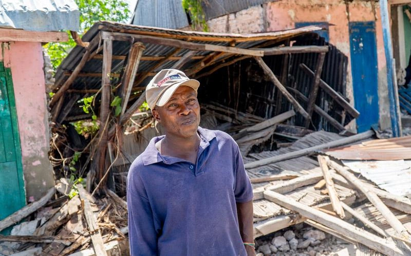 Un Haïtien se tient devant les ruines de ce qui était autrefois sa maison.