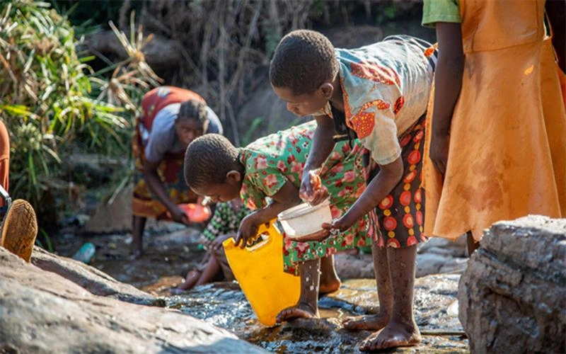 Ireen, originaire du Malawi, va chercher de l'eau dans un ruisseau.