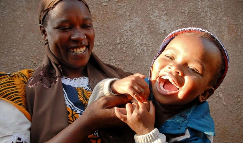 Au Kenya, une mère chatouille sa petite fille, qui rit aux éclats.