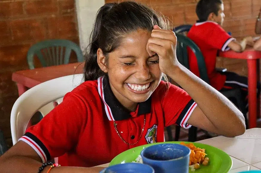 world-vision-canada-end-hunger-girl-enjoying-school-meal.webp