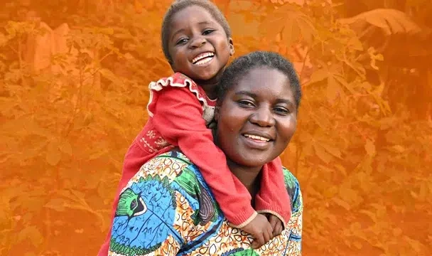 Une mère souriante porte sa fille sur ses épaules.  Une mère souriante porte sa fille sur ses épaules.