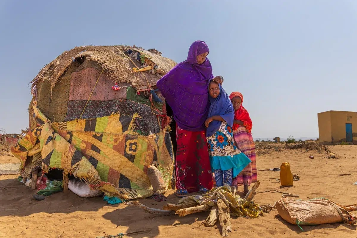 Une famille de réfugiés vit dans une région désertique aride.